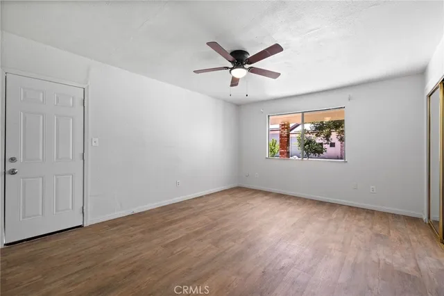 a view of a livingroom with a ceiling fan & entryway