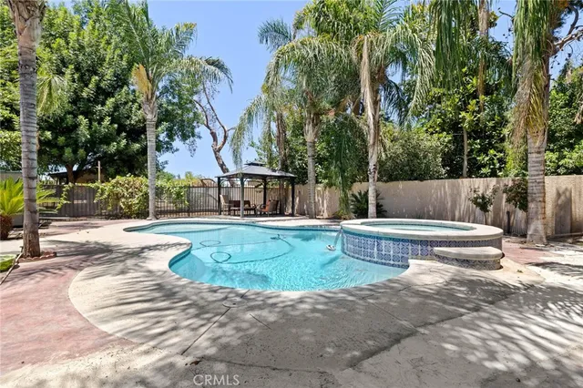 a front view of a house with garden and a tree