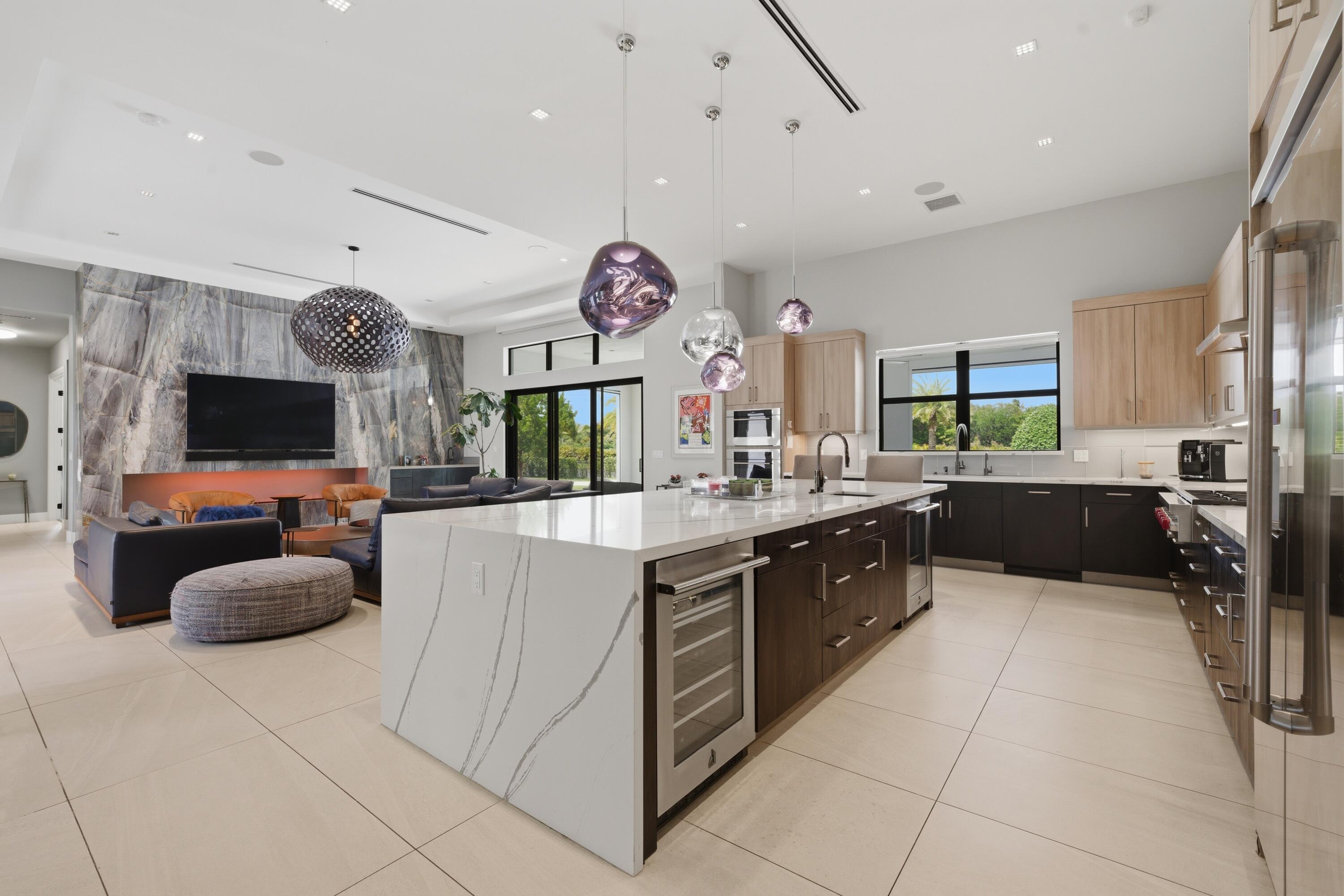 17101 Magnolia Estates Drive Southwest Ranches, FL 33331 - Photo 13 of 57 a large kitchen with stainless steel appliances a large counter top a stove a chimney a sink and a large window