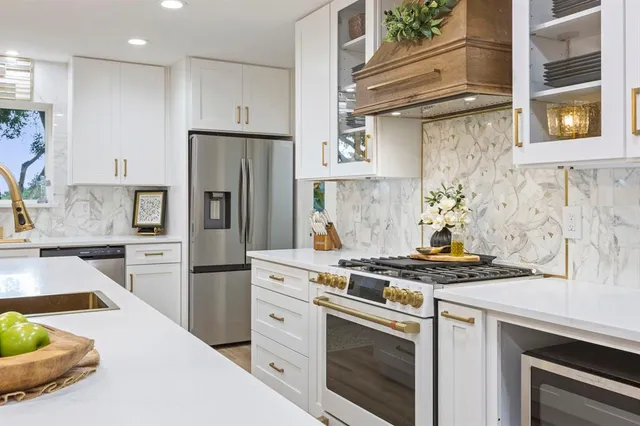 a kitchen with stainless steel appliances granite countertop a stove and a refrigerator