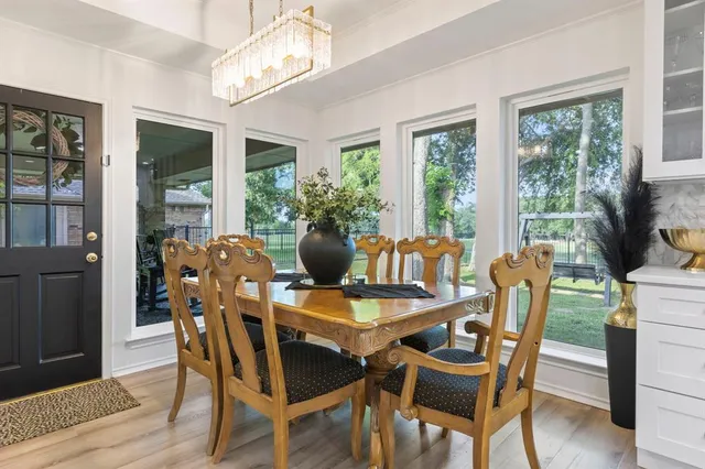 a dining room with furniture a chandelier and wooden floor