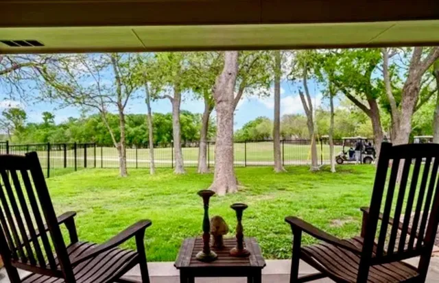 a view of yard with a chair and floor to ceiling window