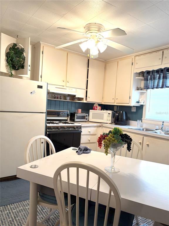 21249 Durden Road Dade City, FL 33523 - Photo 4 of 28 a kitchen with stainless steel appliances a table chairs and a refrigerator