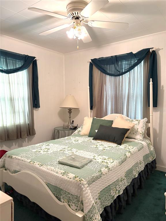 21249 Durden Road Dade City, FL 33523 - Photo 8 of 28 a bedroom with a bed and a chandelier