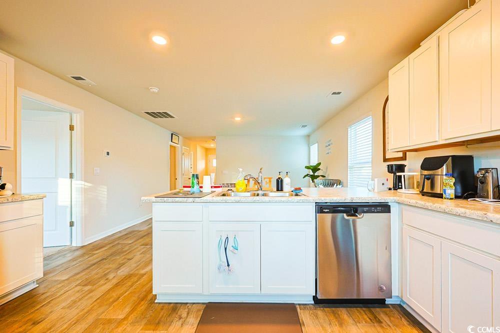 224 Jeff Waters Circle Longs, SC 29568 - Photo 8 of 30 Kitchen featuring white cabinets, stainless steel dishwasher, recessed lighting, a peninsula, and light wood-style floors
