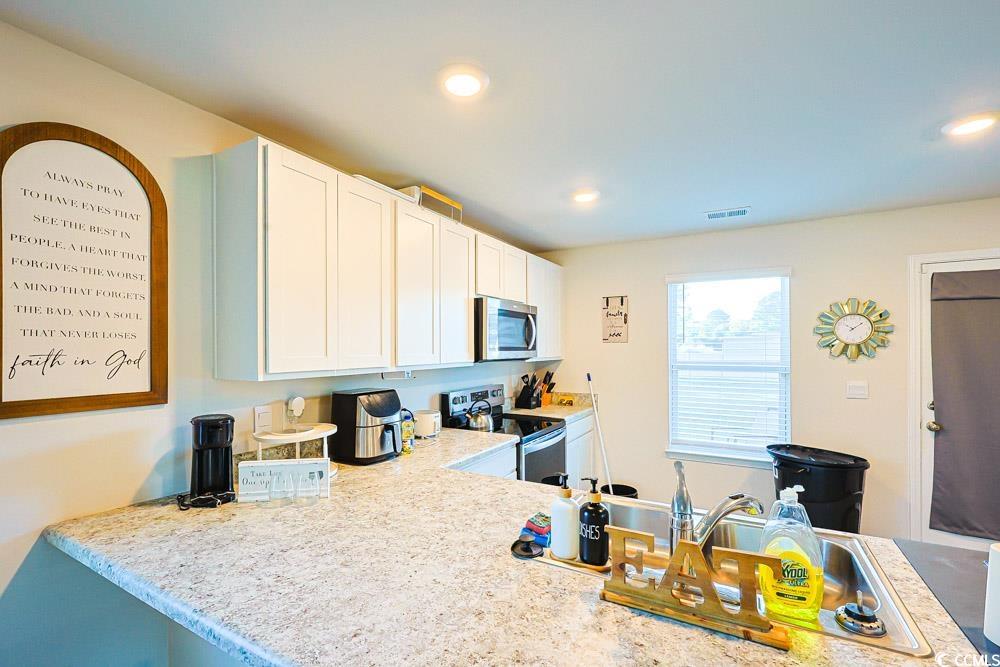 224 Jeff Waters Circle Longs, SC 29568 - Photo 9 of 30 Kitchen with white cabinetry, appliances with stainless steel finishes, recessed lighting, and light stone counters