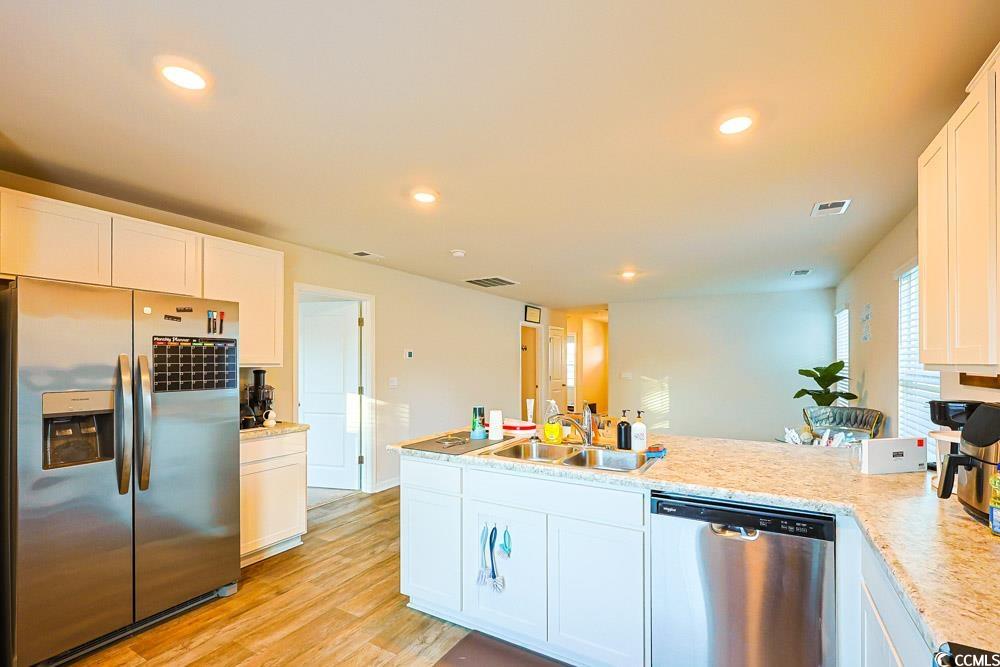 224 Jeff Waters Circle Longs, SC 29568 - Photo 10 of 30 Kitchen with stainless steel appliances, white cabinets, light countertops, light wood-type flooring, and recessed lighting