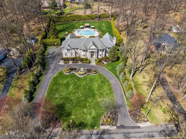 an aerial view of a house with swimming pool and outdoor seating