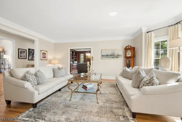 a living room with furniture a rug a fireplace and a window