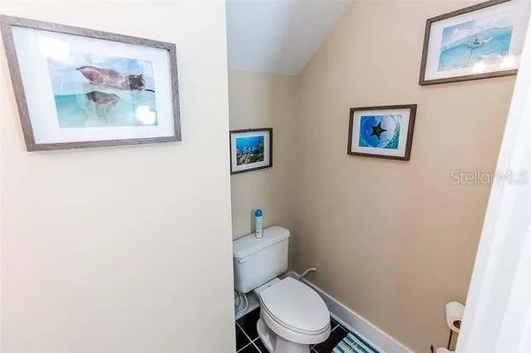 a white toilet sitting next to a white wall