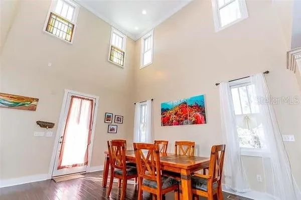 a view of a dining room with furniture a kitchen and wooden floor