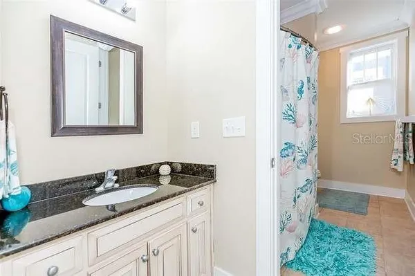 a bathroom with a granite countertop sink a mirror a vanity and a shower