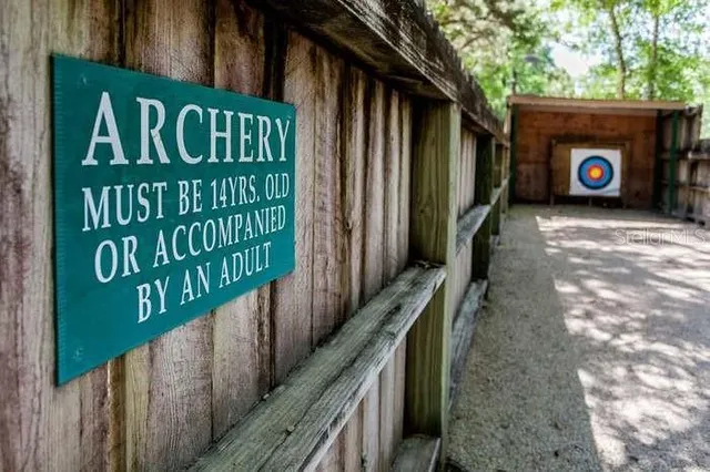 a view of backyard with green space and wooden fence