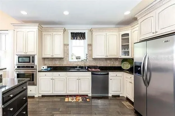 a kitchen with stainless steel appliances granite countertop a stove a sink and a refrigerator