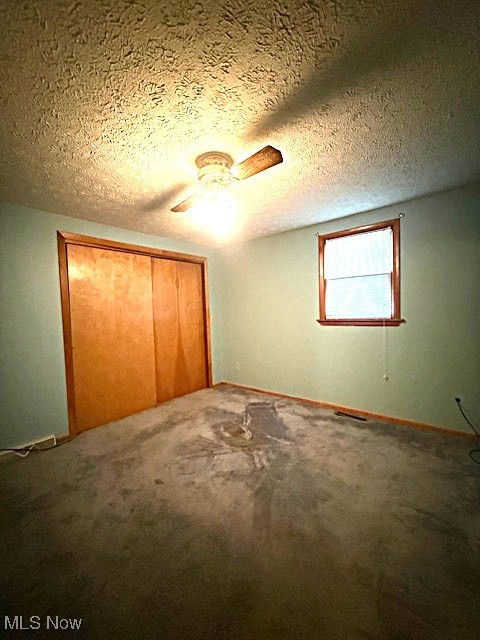 3804 Mahoning Road Northeast Canton, OH 44705 - Photo 16 of 22 Unfurnished bedroom with a closet, baseboards, a ceiling fan, a textured ceiling, and carpet flooring