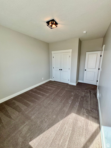 1184 West 3250 North Ogden, UT 84414 - Photo 46 of 69 Light-filled room featuring a large window, neutral wall paint, patterned carpet flooring, and a contemporary ceiling light fixture
