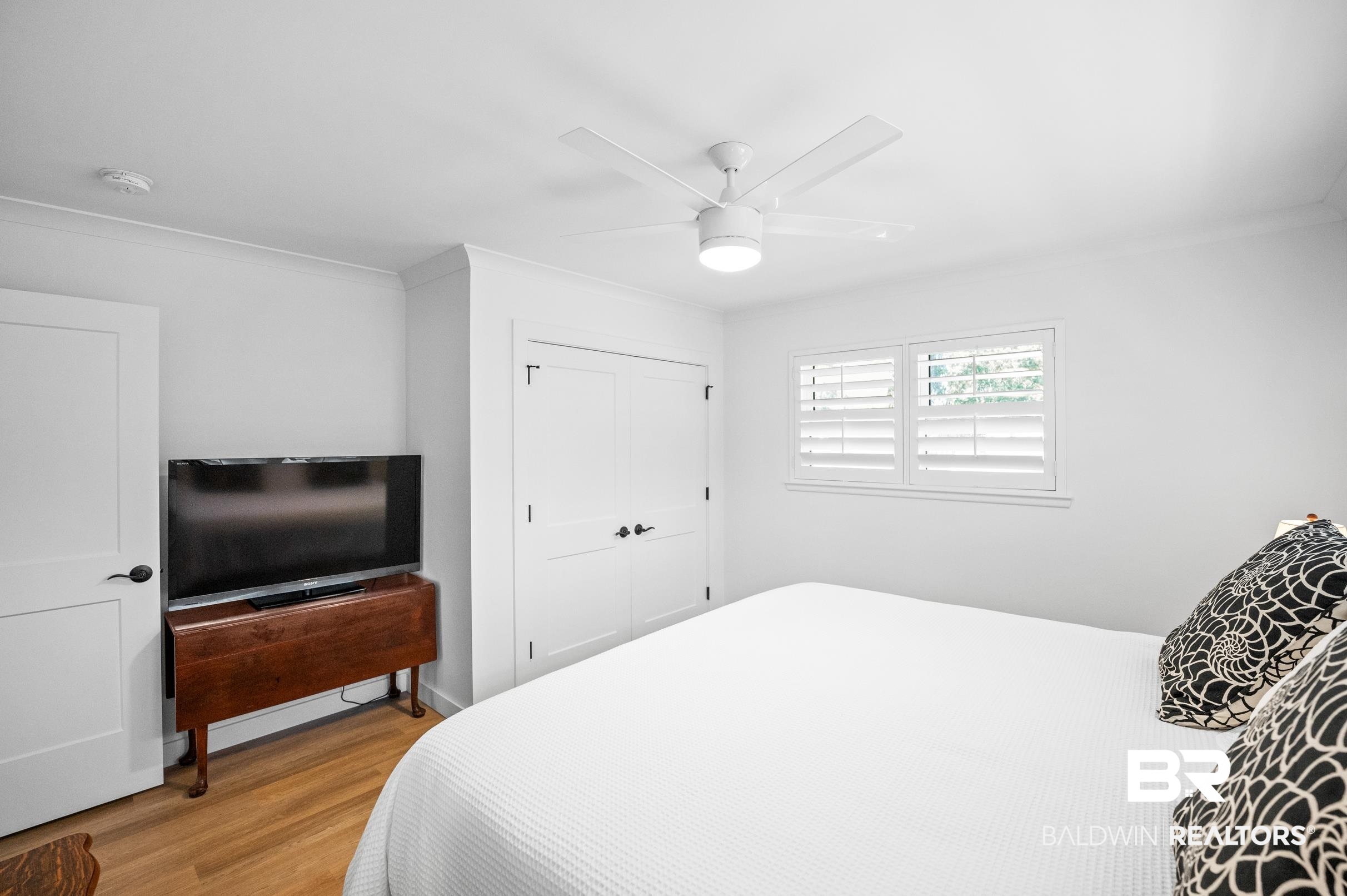 9459 Soldier Creek Road Lillian, AL 36549 - Photo 20 of 54 Bedroom featuring crown molding, a closet, a ceiling fan, and wood finished floors