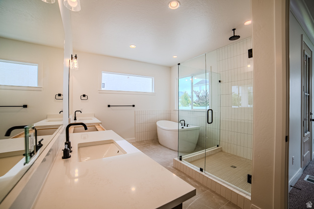 223 South Cottonwood Road, Unit 7501 Vineyard, UT 84059 - Photo 31 of 45 Modern bathroom featuring a dual vanity with undermount sinks and matte black fixtures, a freestanding soaking tub, and a glass-enclosed shower with subway tile surround and rain shower head