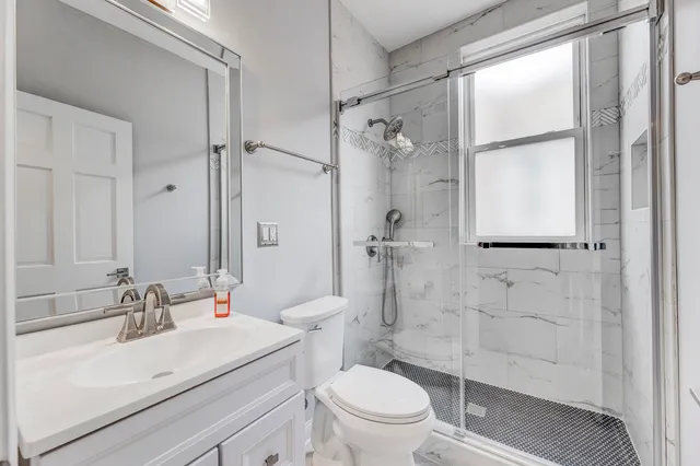 a bathroom with a sink toilet a mirror and shower