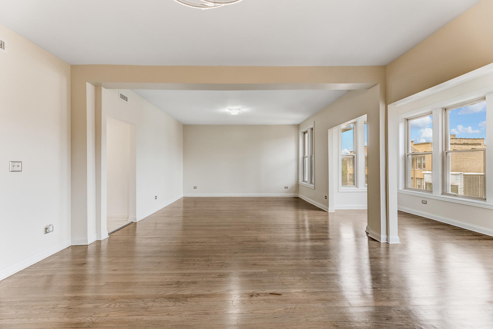 4722 South Ingleside Avenue, Unit 3N Chicago, IL 60615 - Photo 2 of 12 a view of an empty room with wooden floor and a window