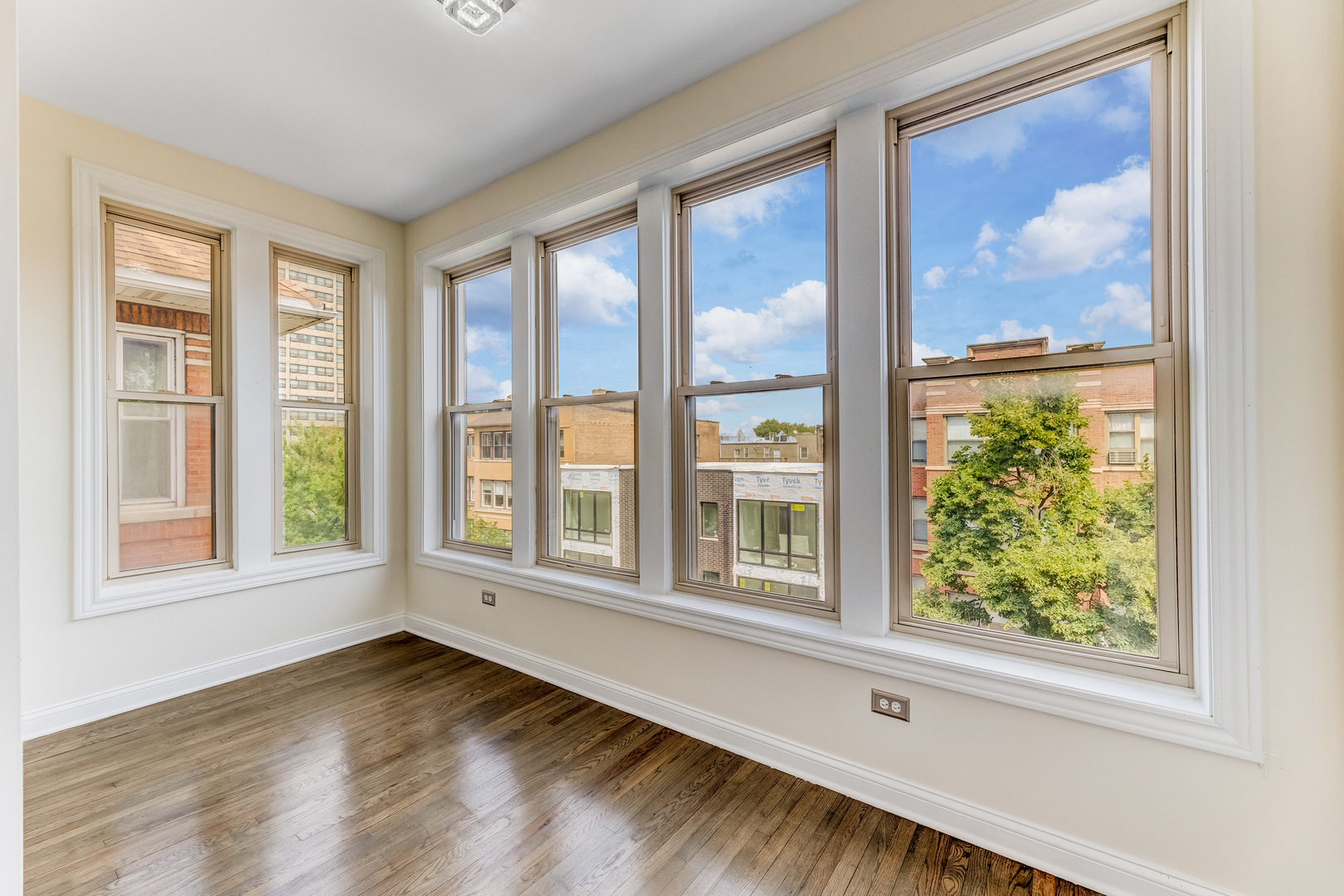 4722 South Ingleside Avenue, Unit 3N Chicago, IL 60615 - Photo 4 of 12 an empty room with wooden floor and windows