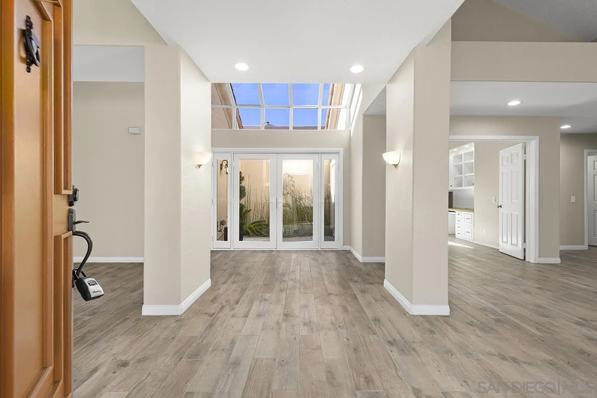 12071 Caminito Corriente San Diego, CA 92128 - Photo 11 of 51 a view of a hallway with wooden floor and a bathroom