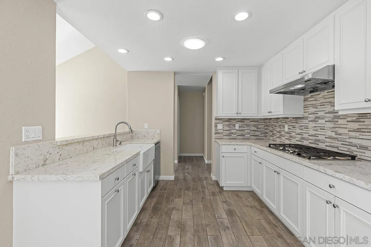 12071 Caminito Corriente San Diego, CA 92128 - Photo 15 of 51 a kitchen with granite countertop a sink stove and cabinets