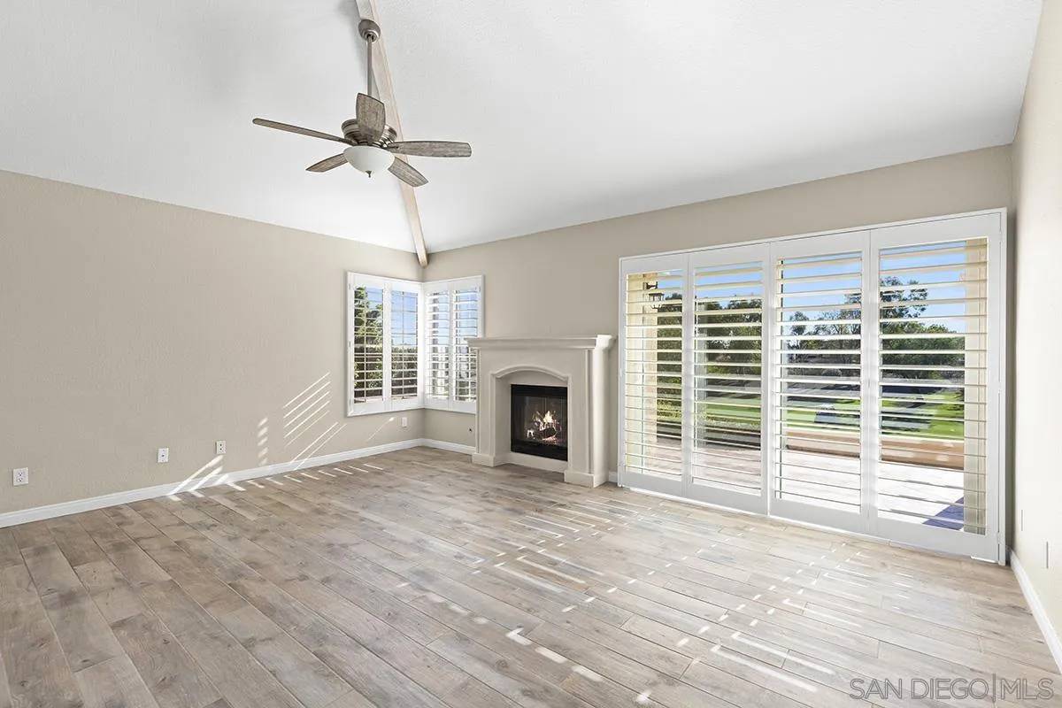 12071 Caminito Corriente San Diego, CA 92128 - Photo 22 of 51 a view of a livingroom with a fireplace a ceiling fan and windows