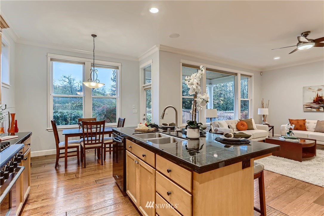 905 South 38th Court Renton, WA 98055 - Photo 16 of 33 a kitchen with granite countertop a table chairs stove and wooden floor