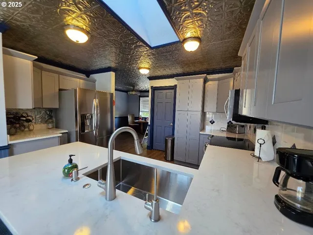 a kitchen with stainless steel appliances a stove sink and microwave