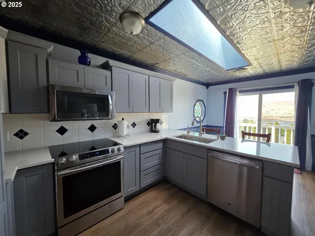 a kitchen with stainless steel appliances granite countertop a refrigerator a sink and a stove