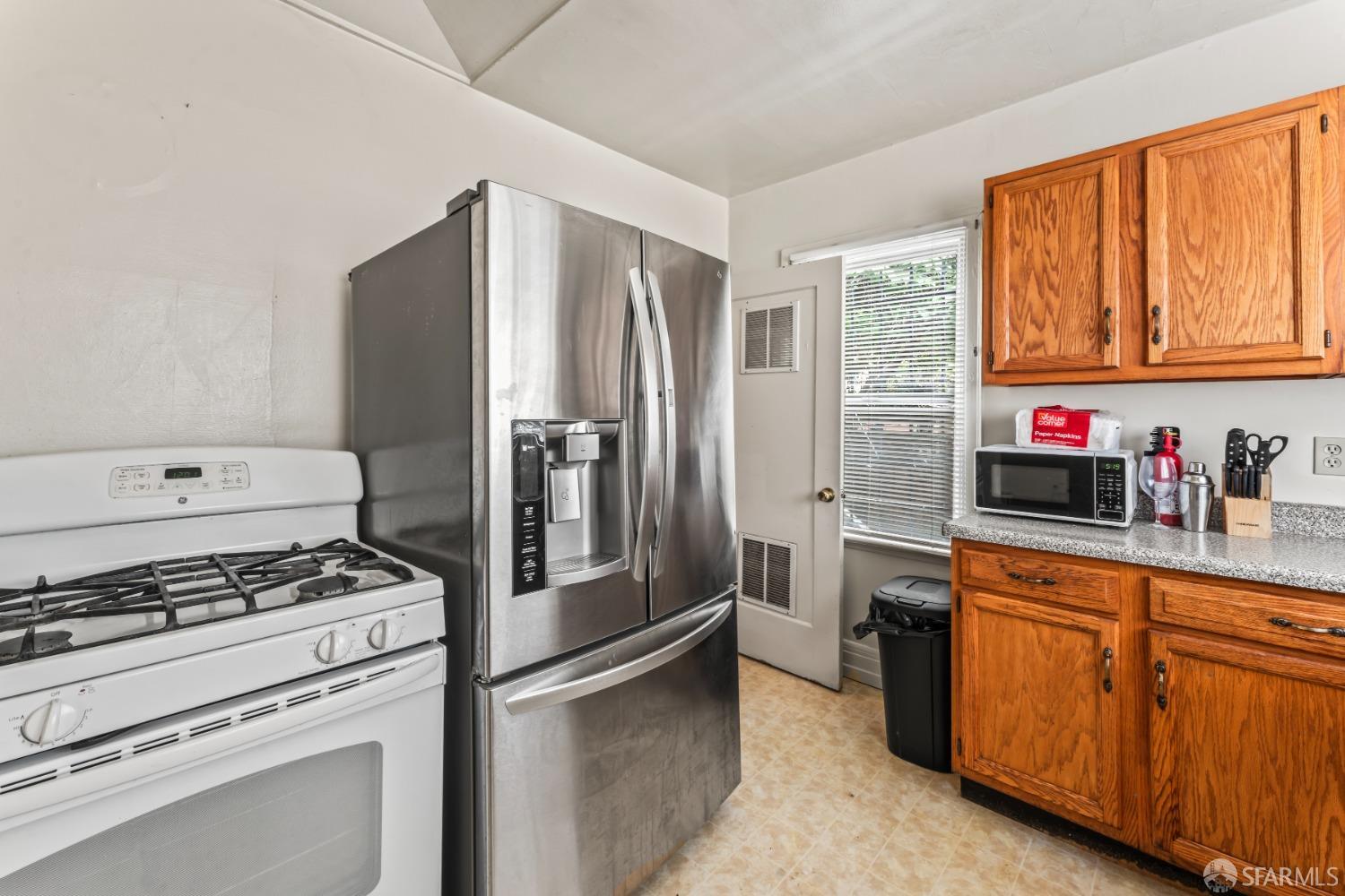 1646 Parker Street Berkeley, CA 94703 - Photo 10 of 33 a kitchen with stainless steel appliances a refrigerator a stove and wooden cabinets