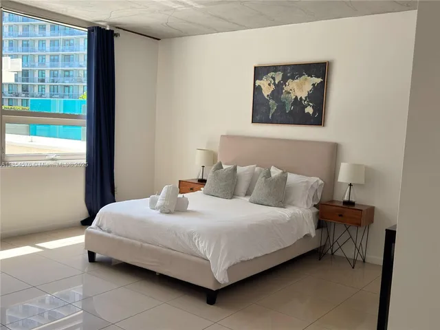 a bedroom with a bed and a wall painting