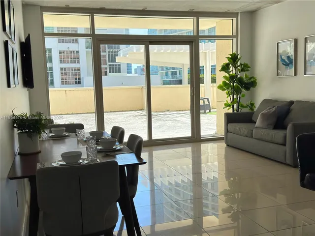 a living room with furniture and large windows