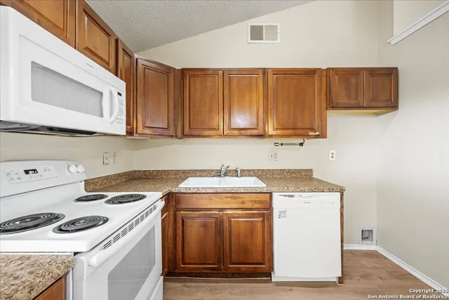 a kitchen with a stove top oven sink and cabinets