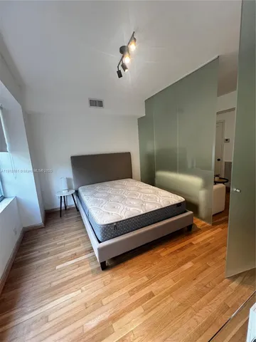 a bedroom with a bed and wooden floor