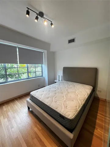 a bed sitting in a bedroom next to a window