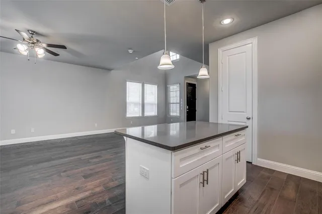 a kitchen with a sink chandelier and wooden floor