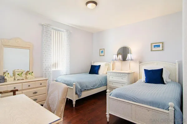 a bedroom with two beds and a dresser