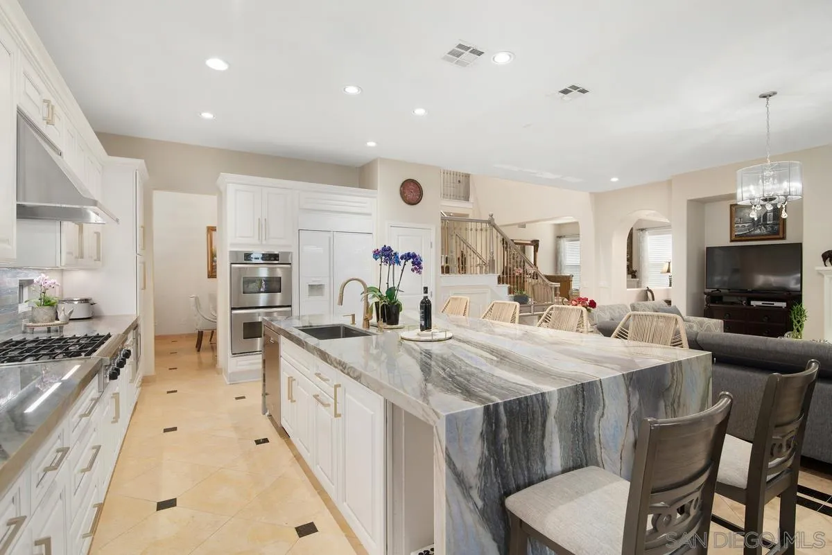 Undisclosed Address San Diego, CA 92130 - Photo 10 of 28 a large kitchen with kitchen island a stove a sink a dining table and chairs