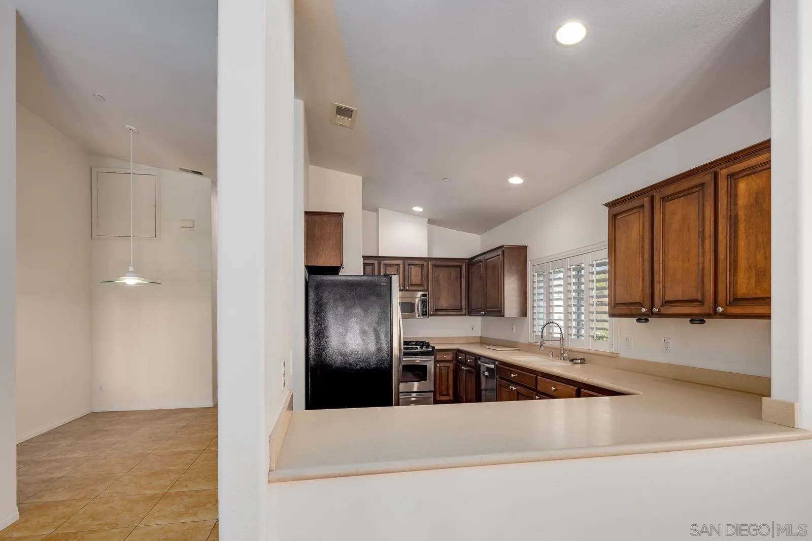 828 D Coronado, CA 92118 - Photo 7 of 24 a kitchen with stainless steel appliances granite countertop a refrigerator and a sink