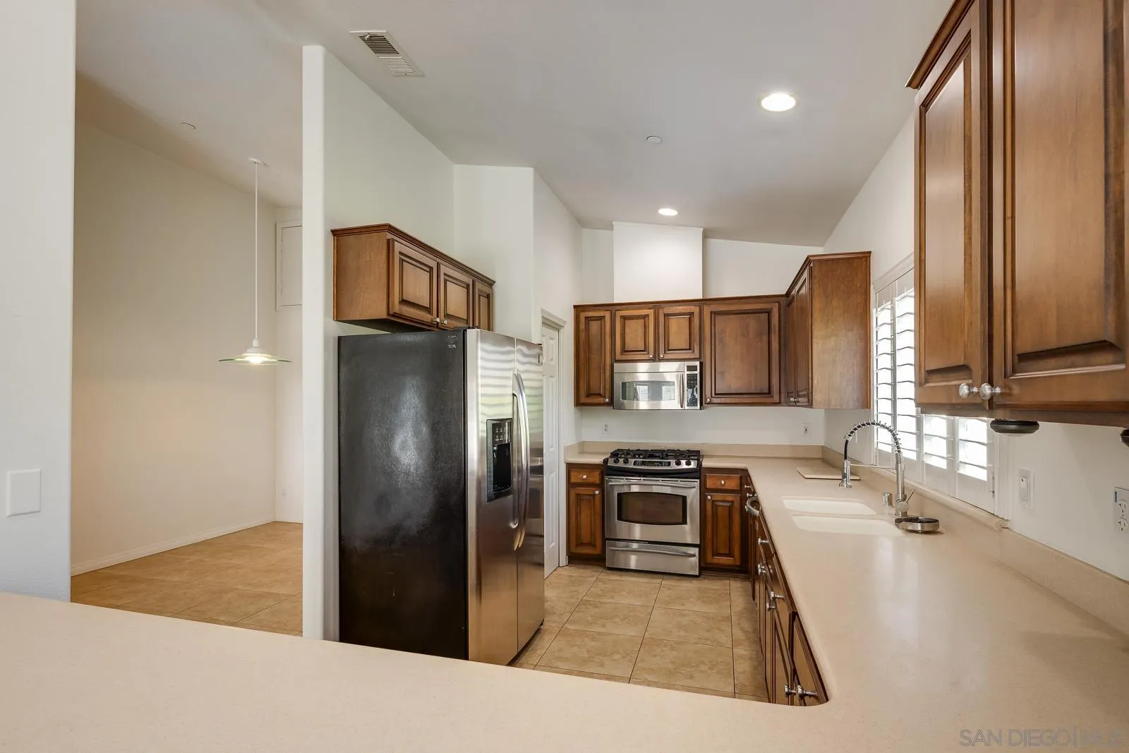 828 D Coronado, CA 92118 - Photo 8 of 24 a kitchen with stainless steel appliances granite countertop a refrigerator a stove and a sink with wooden floor