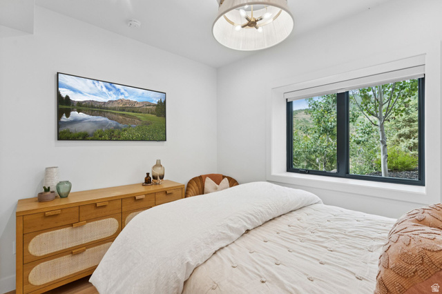 1400 Weber Wild Road Oakley, UT 84055 - Photo 40 of 55 Bright interior featuring a built-in television, wood-finish flooring, a contemporary ceiling light fixture, and a large window with natural surroundings