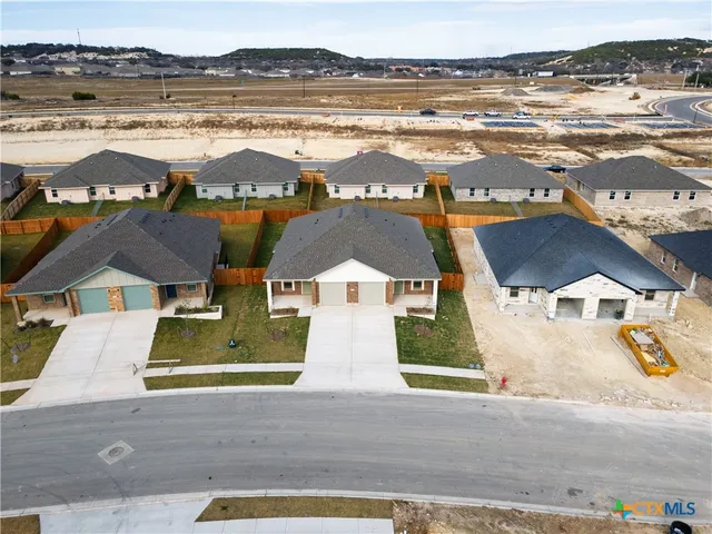 an aerial view of residential houses with outdoor space and ocean view