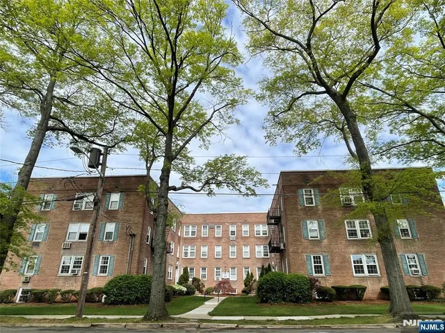 a view of a brick building next to a yard