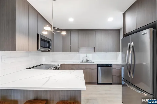 a kitchen with kitchen island a sink stainless steel appliances and cabinets