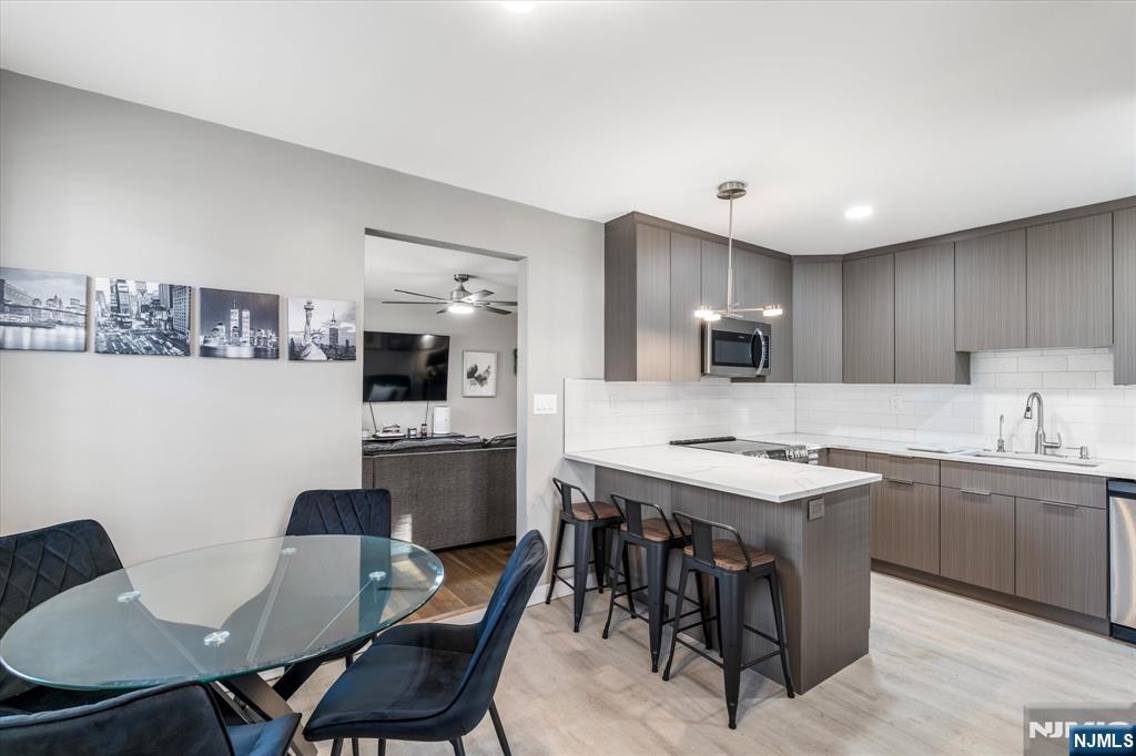 126 Hackett Place, Unit 101A Rutherford, NJ 07070 - Photo 12 of 22 a kitchen with a dining table chairs and microwave