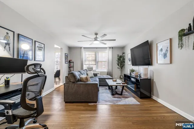 a living room with furniture a flat screen tv and wooden floor