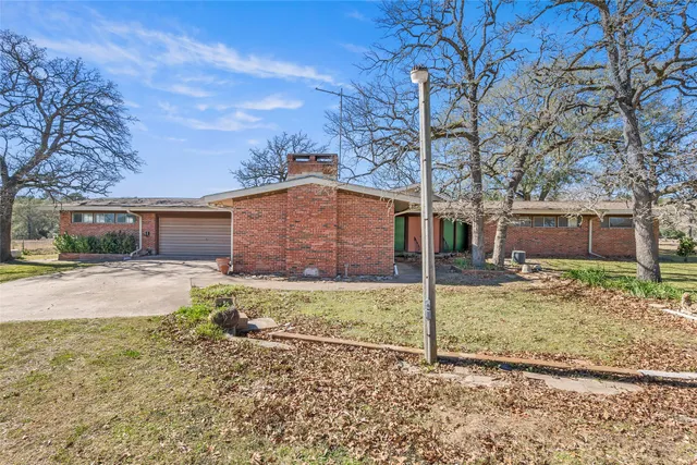a view of a house with a yard covered in the background