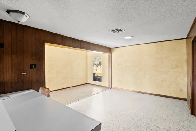 a living room with stainless steel appliances furniture a rug and a kitchen view